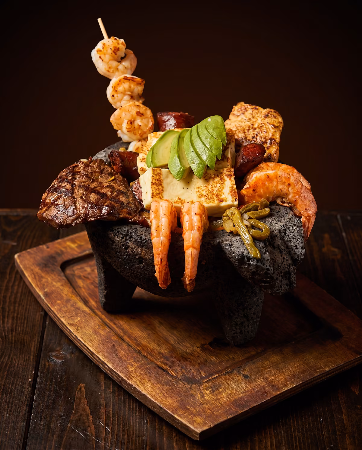 Molcajete Dos Carnales with skirt steak, chicken, shrimp, sausage, cactus and grilled ranchero cheese