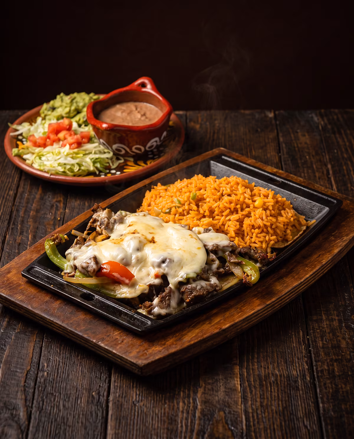 Fajita flameada under Monterey Jack cheese, with rice and guacamole